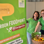 Titelbild mit zwei Mitarbeiterinnen vom Bund Naturschutz in Bayern die neben einem Plakat zur Aktionswoche stehen